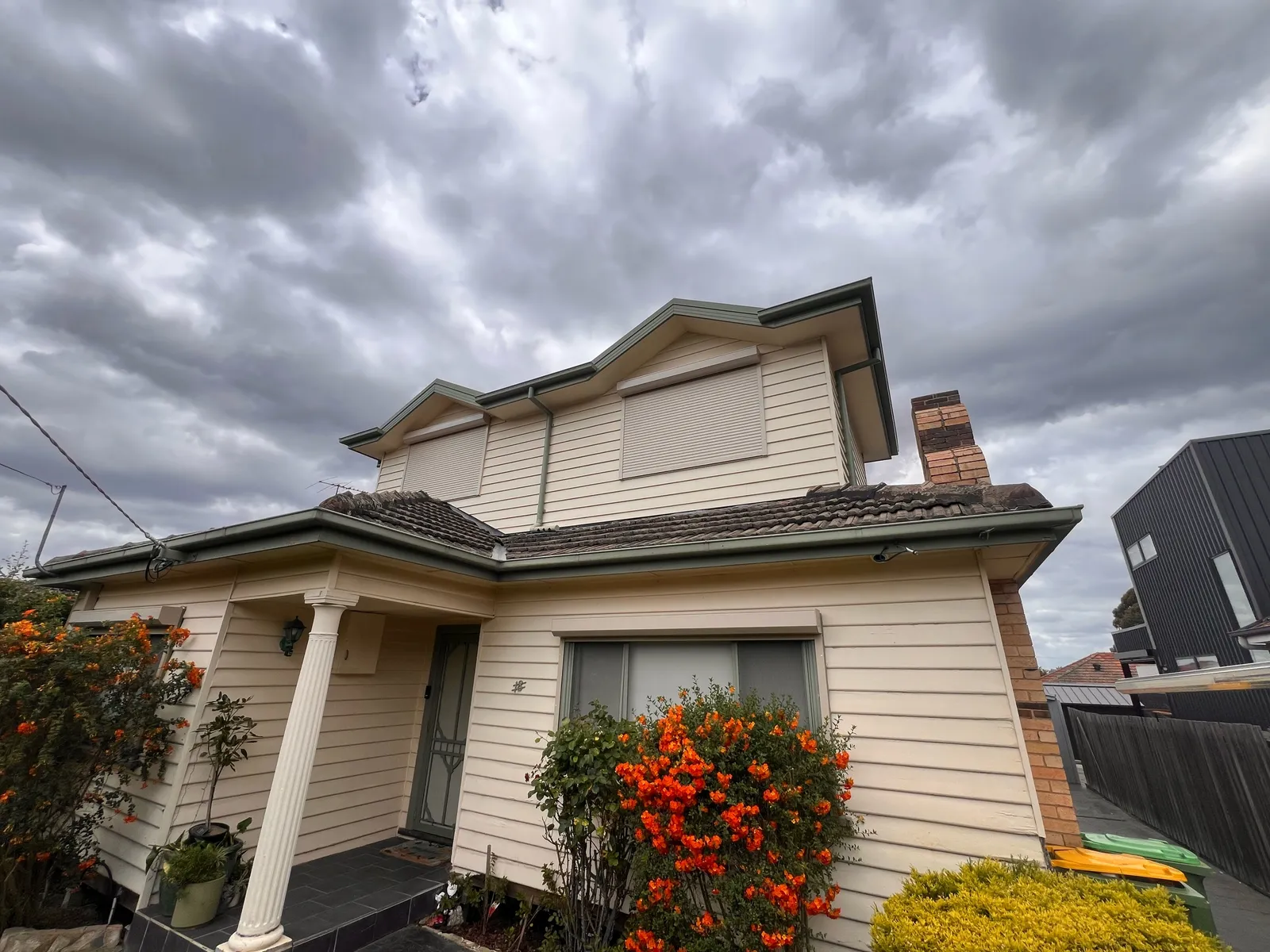 Roller shutter on the upper window of a two-storey weatherboard home