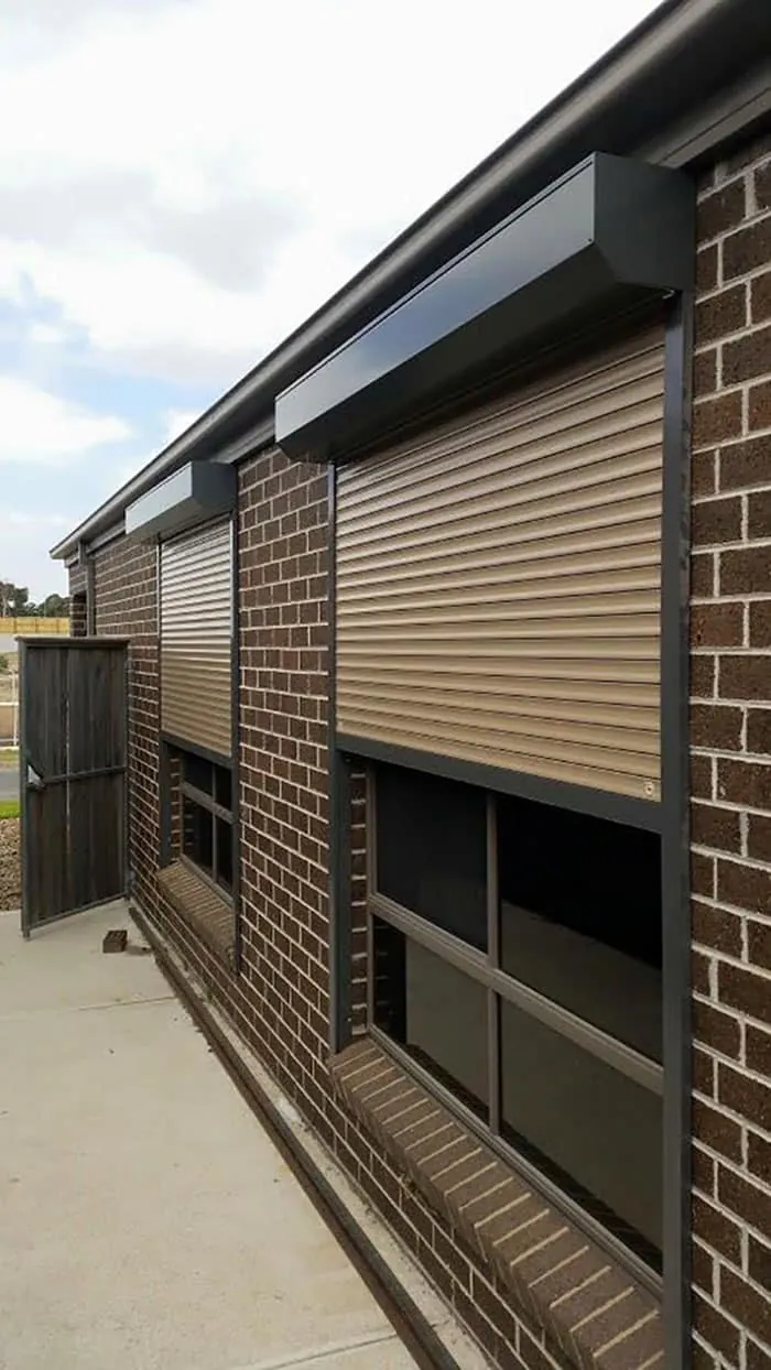 Roller shutters installed on windows of a brick home