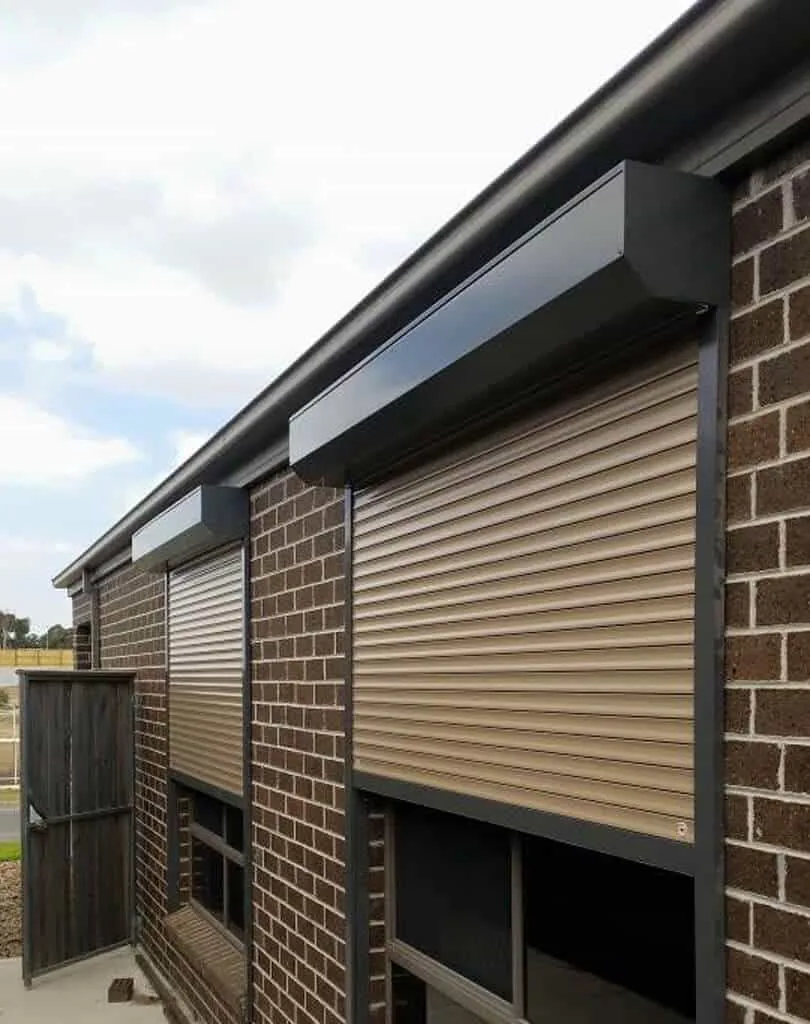 Roller shutter installed over a residential window with contrasting guides and headbox
